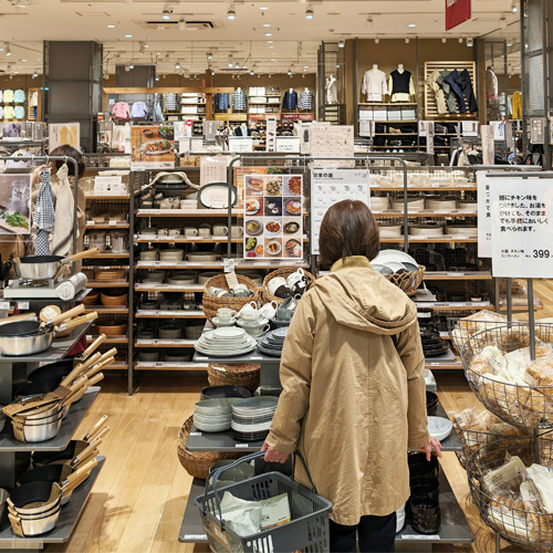 Cliente marche entre les rayons de produits d'un magasin de décoration